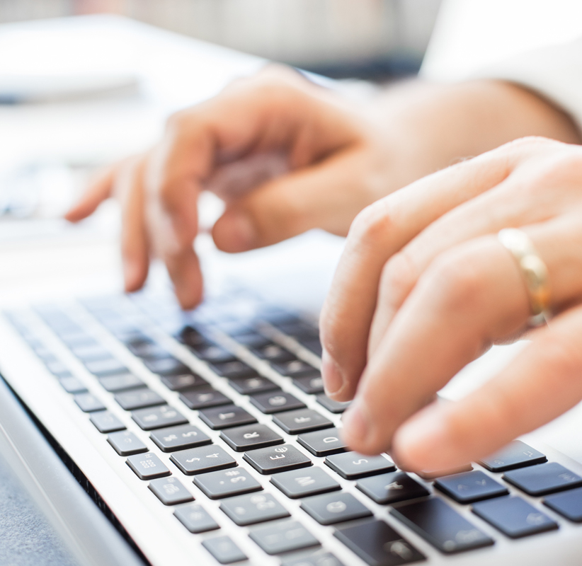 hands typing on a laptop computer