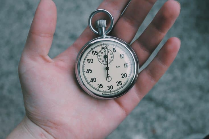 A hand holding a pocket watch.